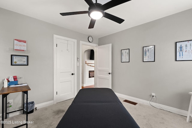 bedroom with baseboards, a ceiling fan, visible vents, and light colored carpet