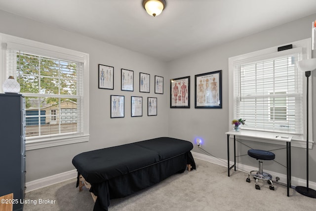 bedroom with light colored carpet and baseboards