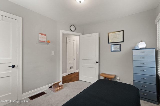 bedroom featuring baseboards, visible vents, and light colored carpet