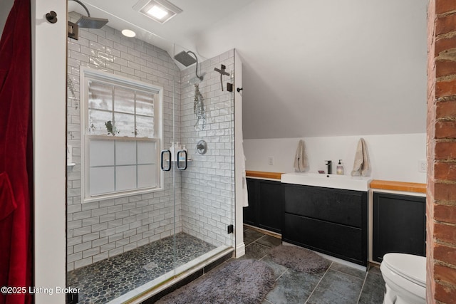 bathroom with lofted ceiling, a shower stall, toilet, and vanity