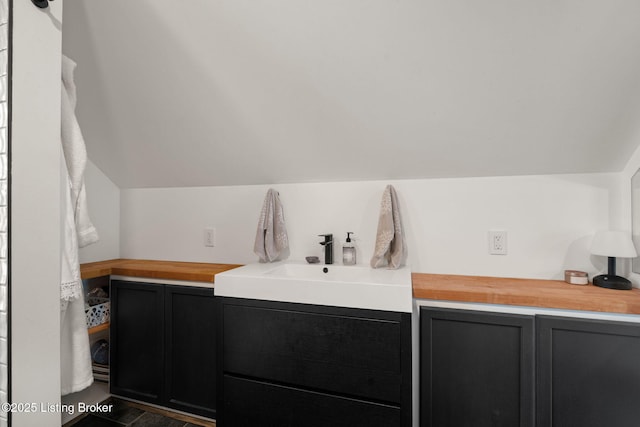 bathroom featuring lofted ceiling and a sink