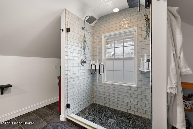 full bath with a shower stall, baseboards, vaulted ceiling, and tile patterned floors