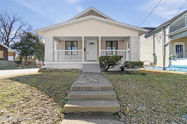 bungalow-style house featuring a porch and brick siding