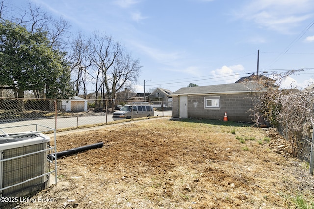 view of yard featuring central AC and fence