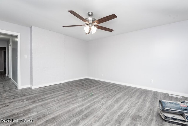 empty room with a ceiling fan, baseboards, and wood finished floors