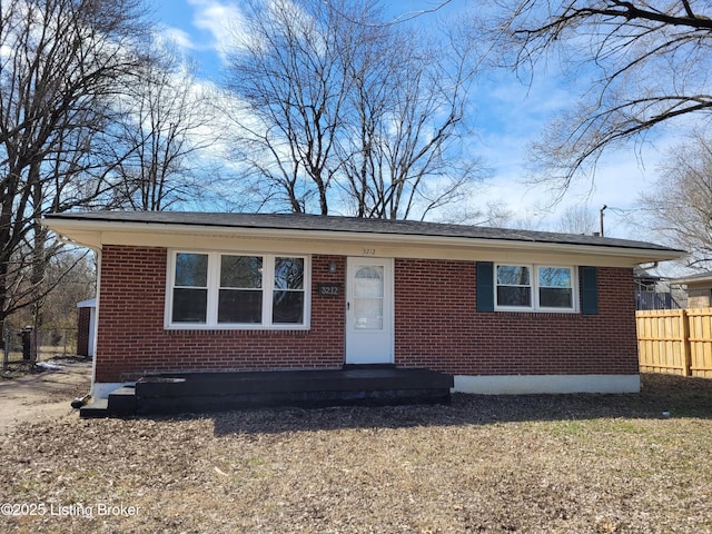 view of front facade with fence and brick siding