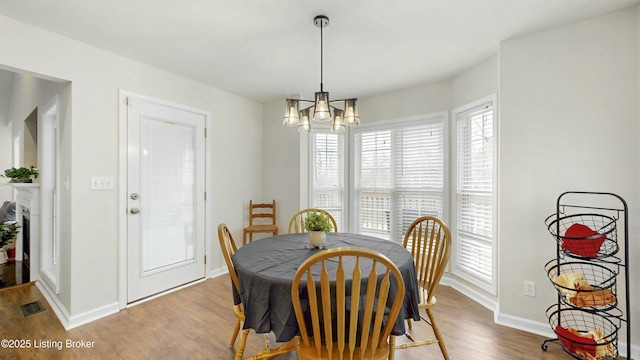 dining area featuring a notable chandelier, baseboards, and wood finished floors