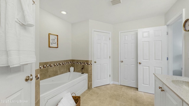 full bath with a bath, vanity, and visible vents