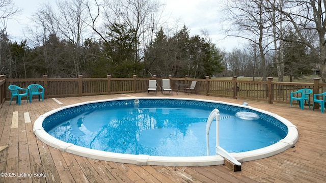 view of swimming pool with a fenced in pool and a wooden deck