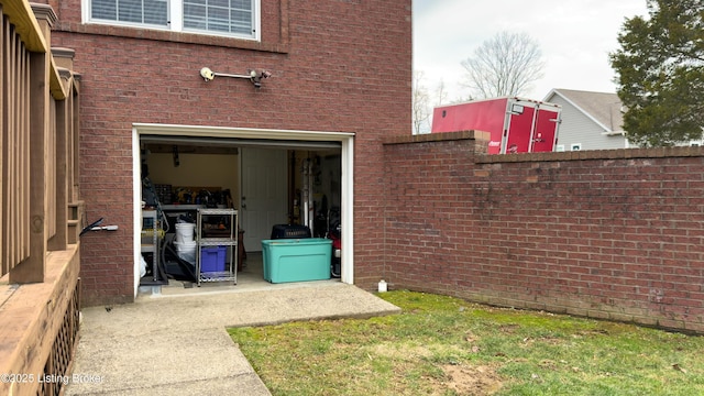 entrance to property featuring a garage and brick siding