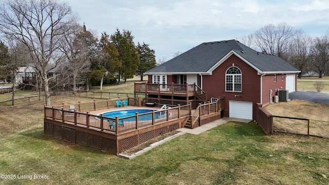 view of pool featuring a wooden deck, central AC unit, a fenced in pool, a fenced backyard, and a yard