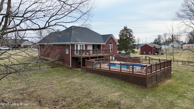 rear view of property with fence, a deck, a fenced in pool, and a yard