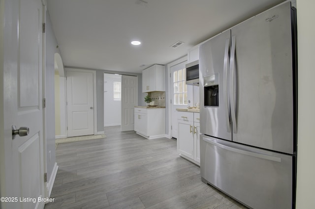 kitchen featuring visible vents, white cabinets, light countertops, appliances with stainless steel finishes, and light wood-type flooring