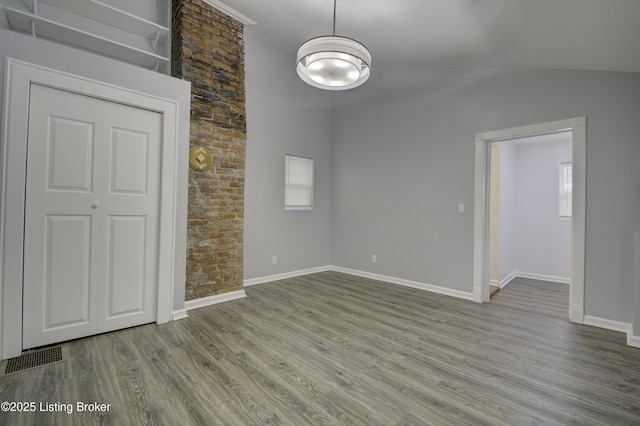 interior space with visible vents, lofted ceiling, light wood-style flooring, and baseboards