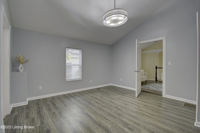 unfurnished bedroom featuring baseboards, vaulted ceiling, and wood finished floors