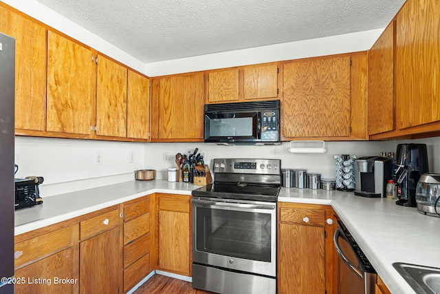 kitchen featuring brown cabinetry, appliances with stainless steel finishes, and light countertops