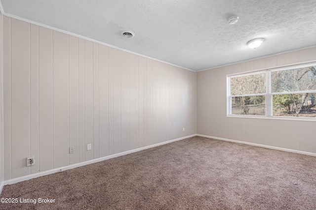 carpeted empty room featuring crown molding, visible vents, and a textured ceiling