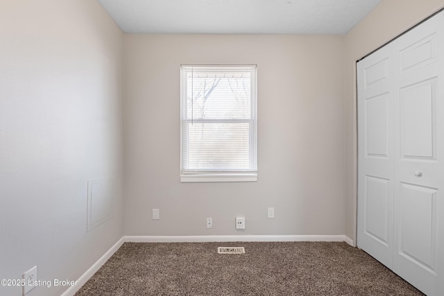 unfurnished bedroom featuring visible vents, a closet, baseboards, and carpet flooring