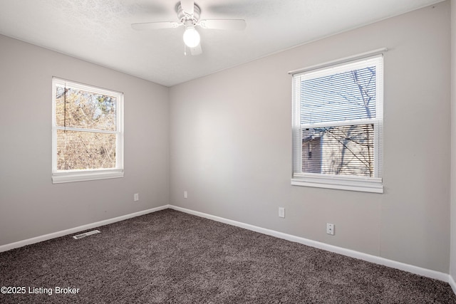 carpeted empty room featuring baseboards, visible vents, and a healthy amount of sunlight