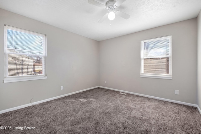 carpeted empty room with a ceiling fan, visible vents, a textured ceiling, and baseboards