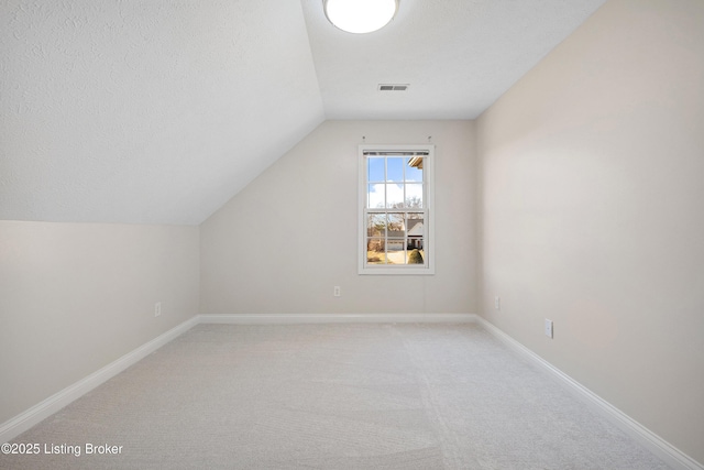 1523 Yorkshire Dr, Elizabethtown, KY 42701 - bonus room featuring visible vents, light carpet, vaulted ceiling, a textured ceiling, and baseboards