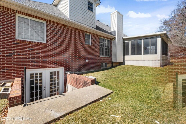 1523 Yorkshire Dr, Elizabethtown, KY 42701 - view of side of home featuring brick siding, a sunroom, french doors, a lawn, and a chimney