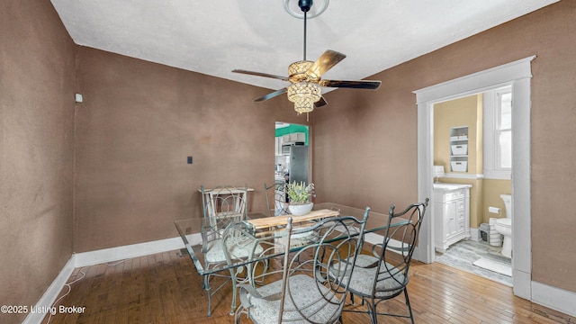 dining space with ceiling fan, baseboards, and hardwood / wood-style flooring