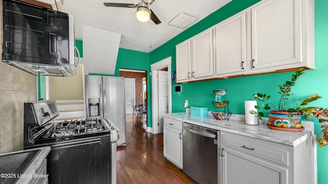 kitchen with appliances with stainless steel finishes, a ceiling fan, white cabinetry, and wood finished floors