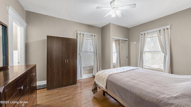 bedroom with ceiling fan, light wood finished floors, and baseboards