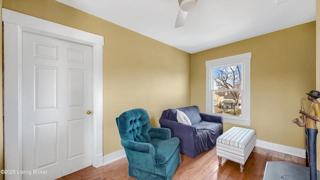 sitting room featuring hardwood / wood-style flooring, baseboards, and a ceiling fan