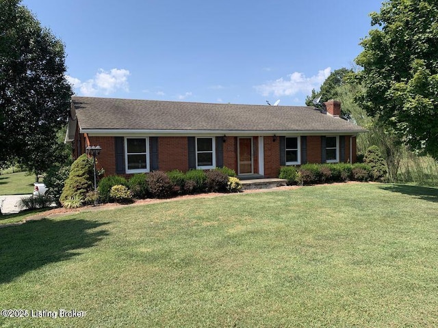 ranch-style house featuring brick siding, a chimney, and a front yard