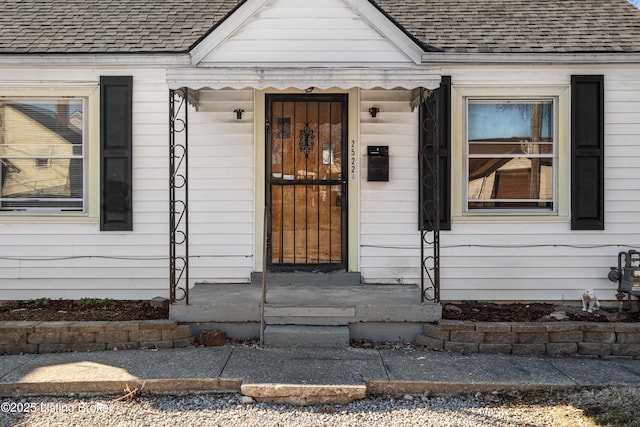 entrance to property with roof with shingles