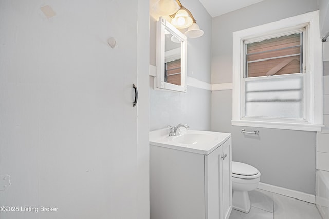 full bathroom with a tub to relax in, tile patterned flooring, toilet, vanity, and baseboards