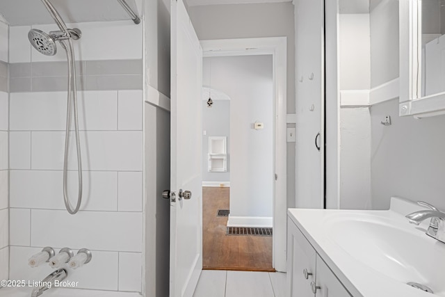 bathroom featuring a shower, wood finished floors, and vanity