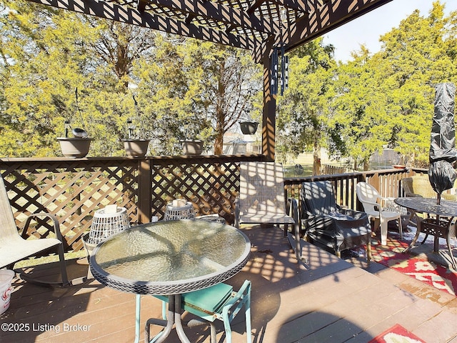 view of patio featuring outdoor dining area, a wooden deck, and a pergola