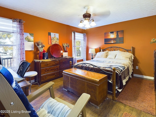 bedroom with ceiling fan, baseboards, and wood finished floors