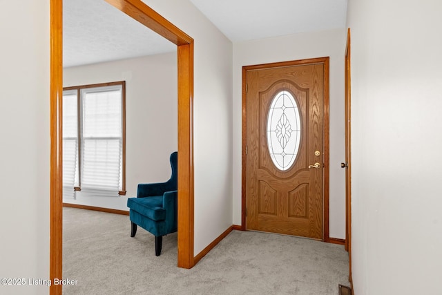 carpeted foyer with a healthy amount of sunlight and baseboards