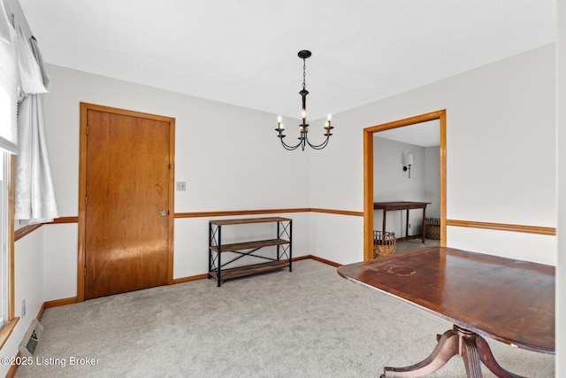 dining space featuring a chandelier, carpet floors, and baseboards