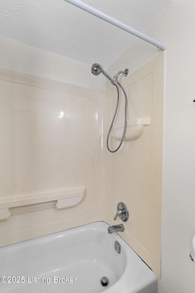 bathroom featuring shower / washtub combination and a textured ceiling