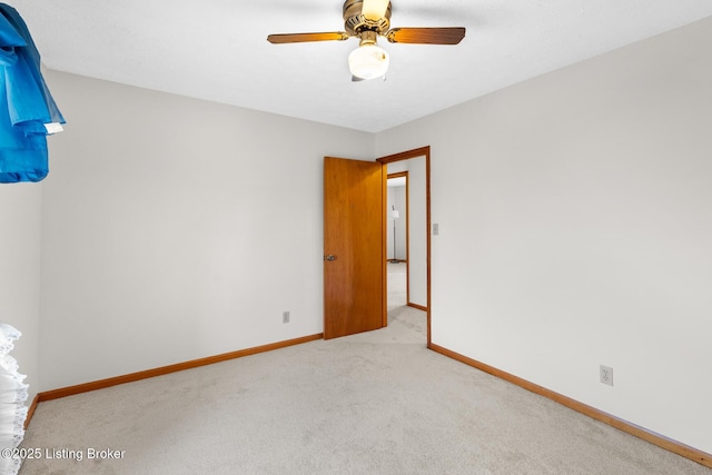 unfurnished room featuring carpet floors, baseboards, and a ceiling fan