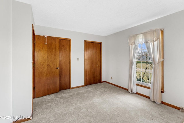 unfurnished bedroom with carpet floors and baseboards