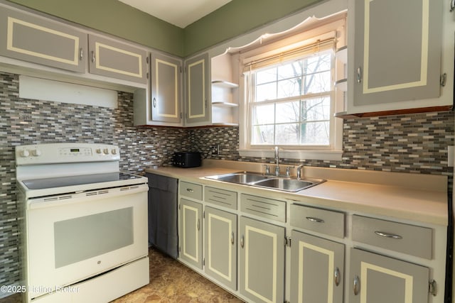 kitchen with white electric range oven, tasteful backsplash, light countertops, and a sink