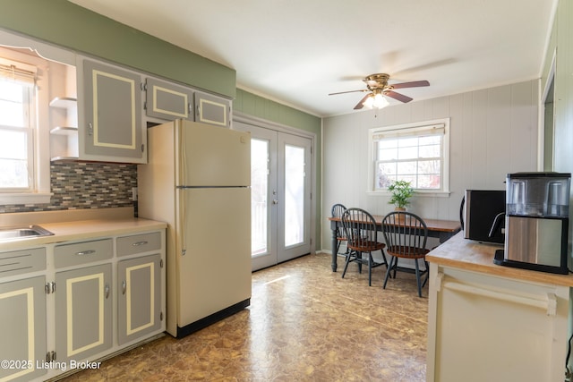 kitchen with freestanding refrigerator, french doors, light countertops, and plenty of natural light