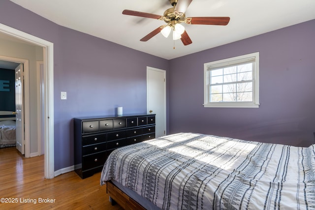 bedroom featuring a ceiling fan, baseboards, and wood finished floors