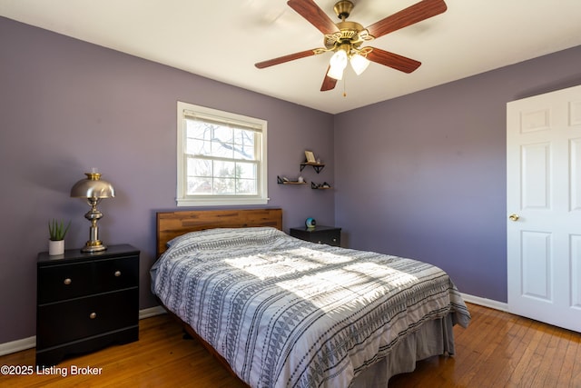 bedroom featuring wood-type flooring, ceiling fan, and baseboards