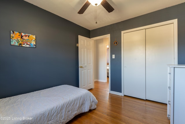 bedroom with ceiling fan, baseboards, and wood finished floors