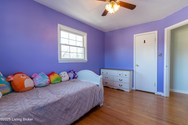 bedroom featuring light wood-style flooring, baseboards, and ceiling fan