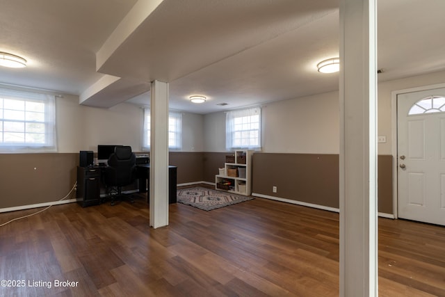 below grade area featuring dark wood-type flooring and baseboards