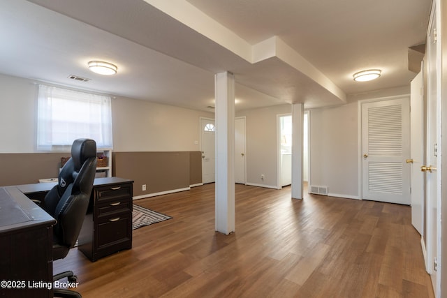 home office with plenty of natural light, visible vents, and wood finished floors