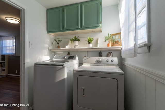 washroom featuring wainscoting, dark wood-style floors, and washing machine and clothes dryer